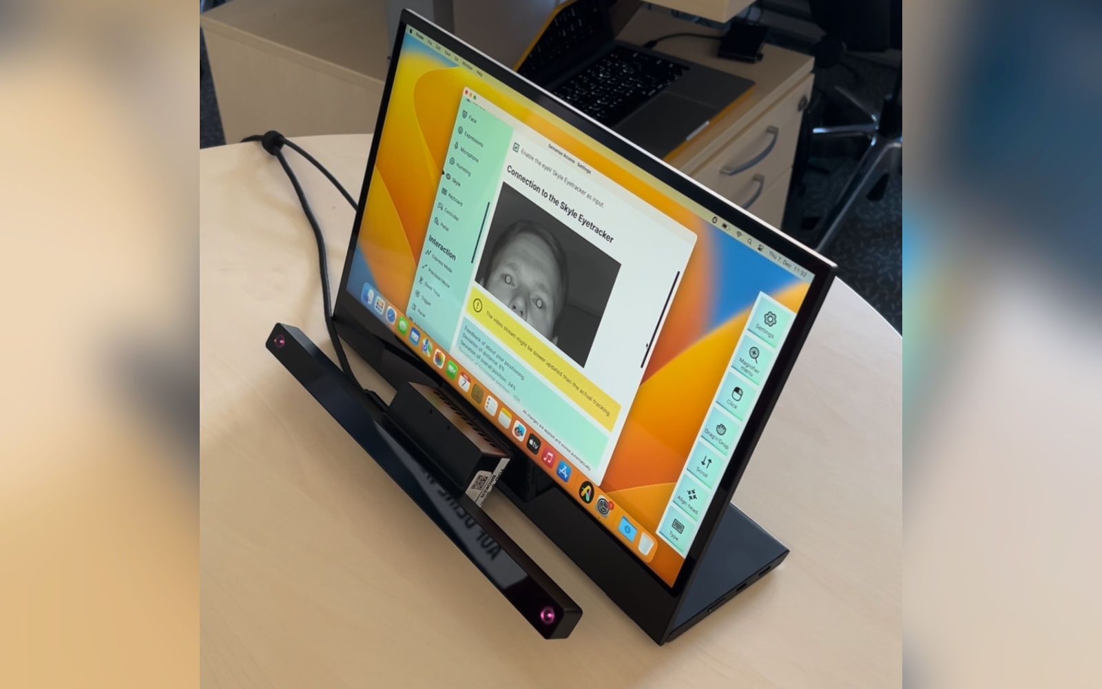 A display with attached eye tracker showing macOS.